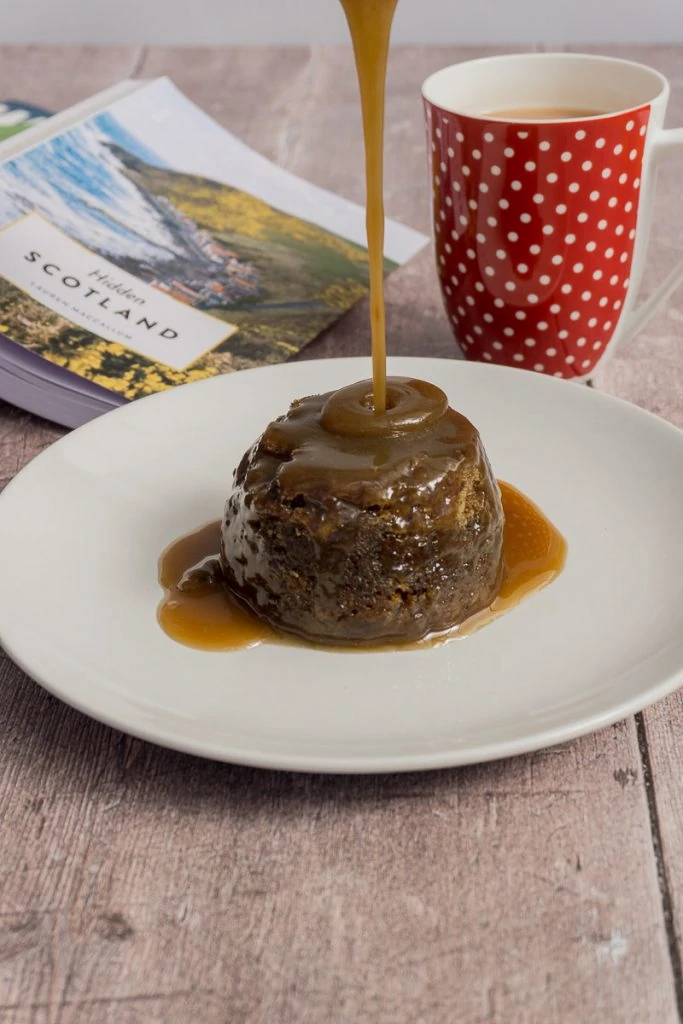 Sticky Toffee Pudding with sauce pouring on it