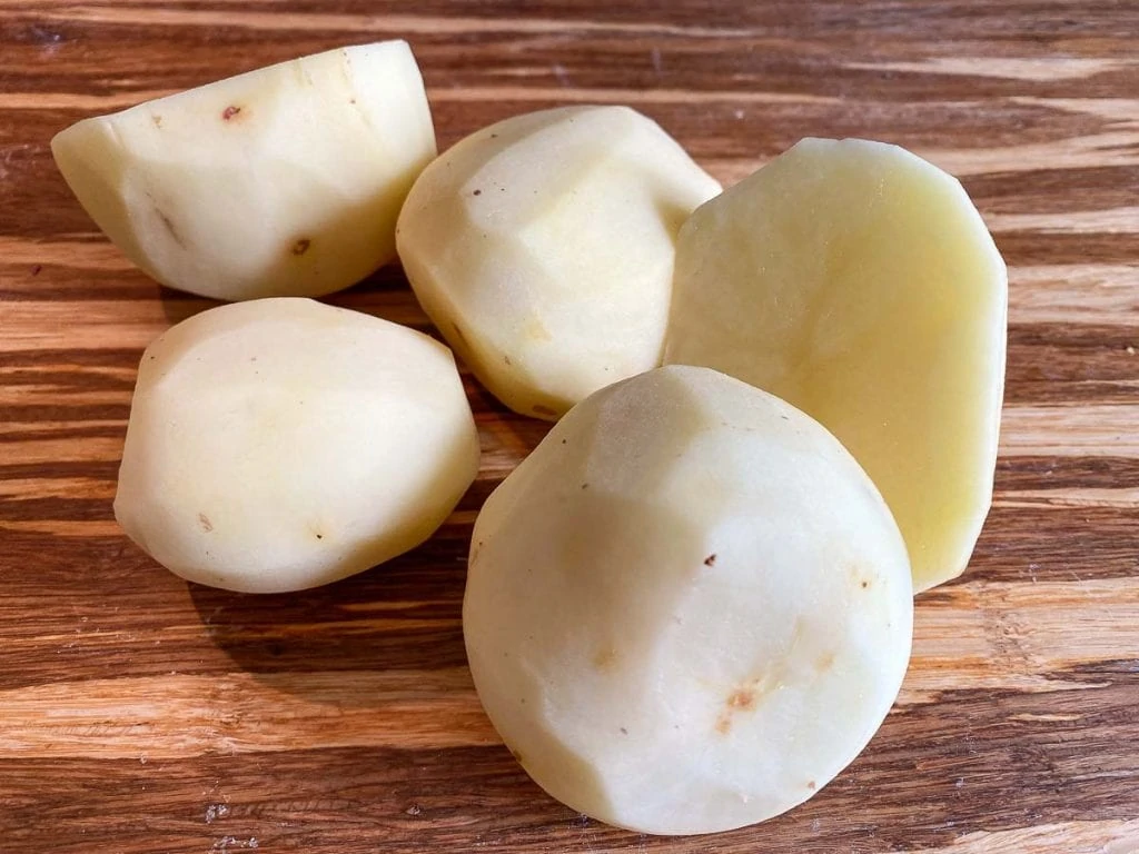 Potatoes on chopping board for making Scottish Tattie Scones Recipe