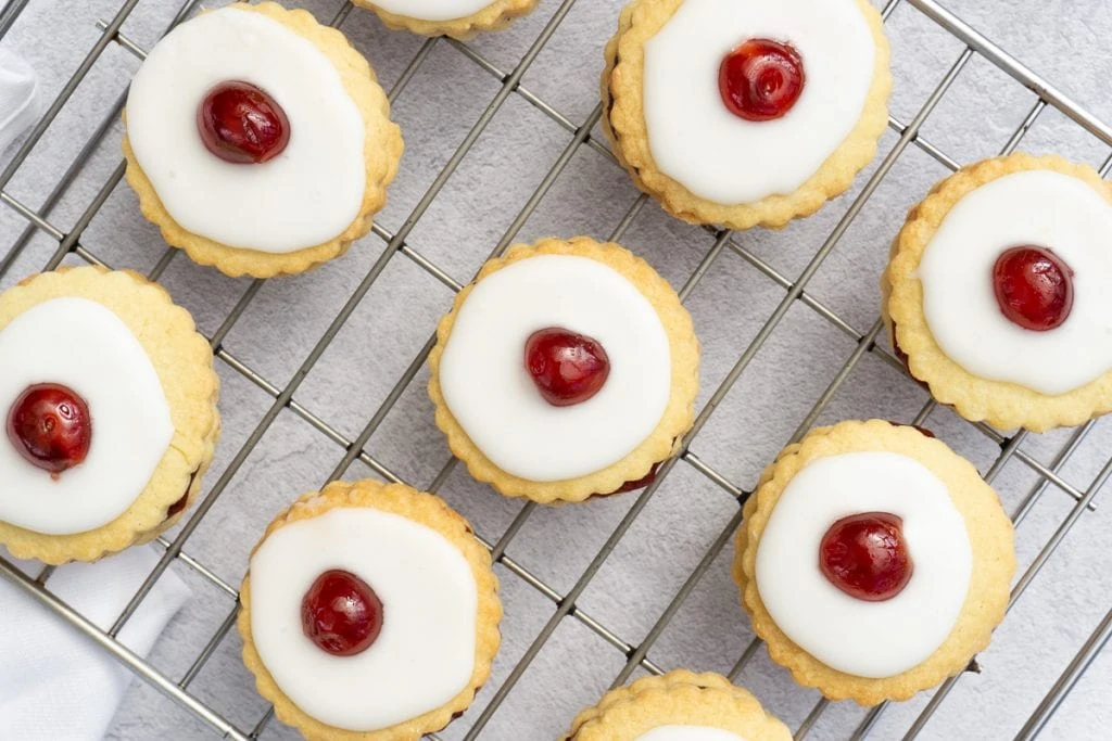 Scottish Double Biscuits - Scottish Iced Biscuits on a cooking rack with a cherry on top