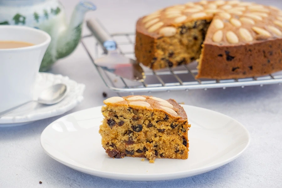 Dundee Cake recipe slice with a cup of tea and cake in the background