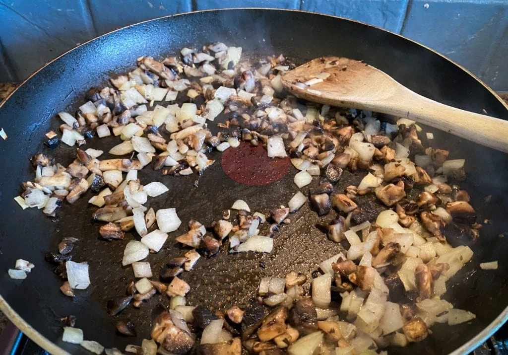 Onion and mushroom frying in a pan for vegan haggis recipe