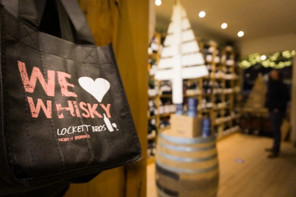 We Love Whisky bag hanging in bottle store