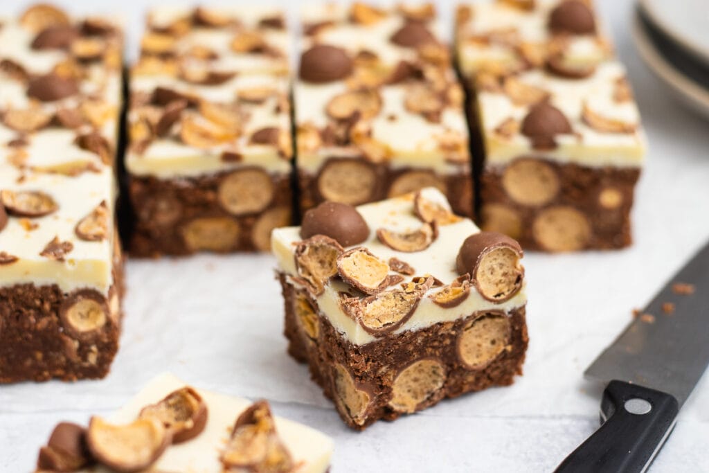 Malteser Traybake Recipe - Slices with a knife nearby