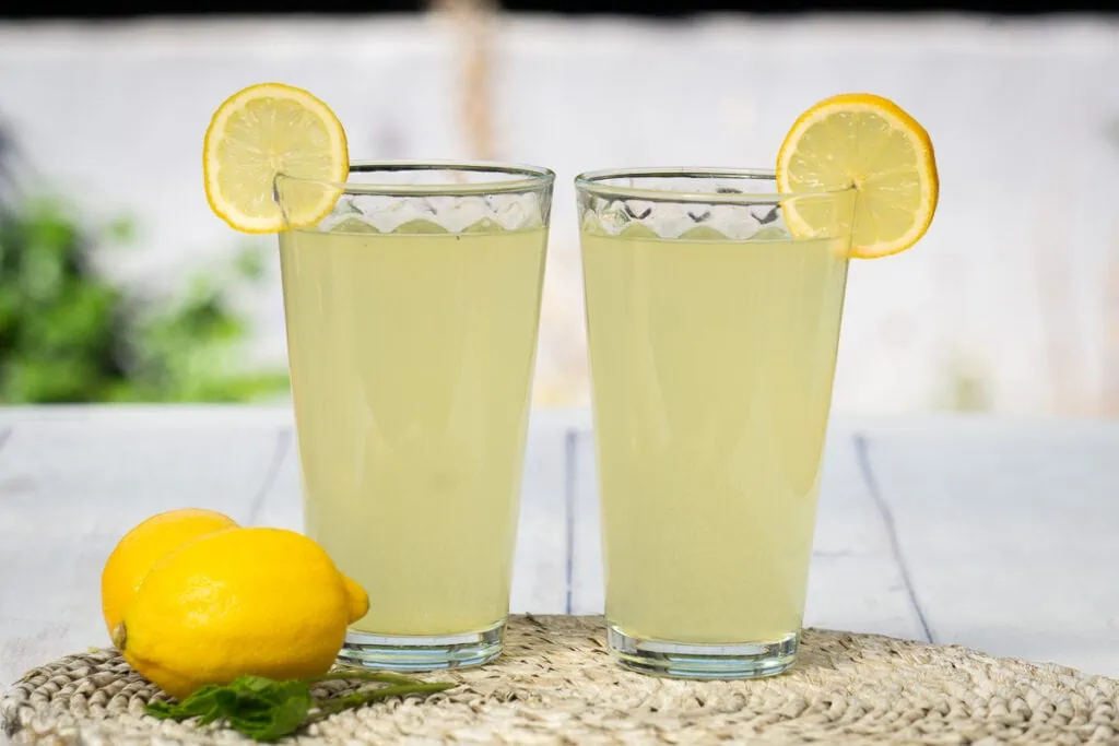Homemade Lemon Cordial Recipe -  two glasses of lemon cordial garnished with lemon