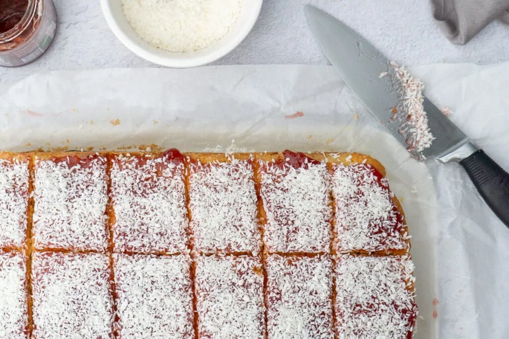 Jam and Coconut Sponge Traybake Recipe cut in squares