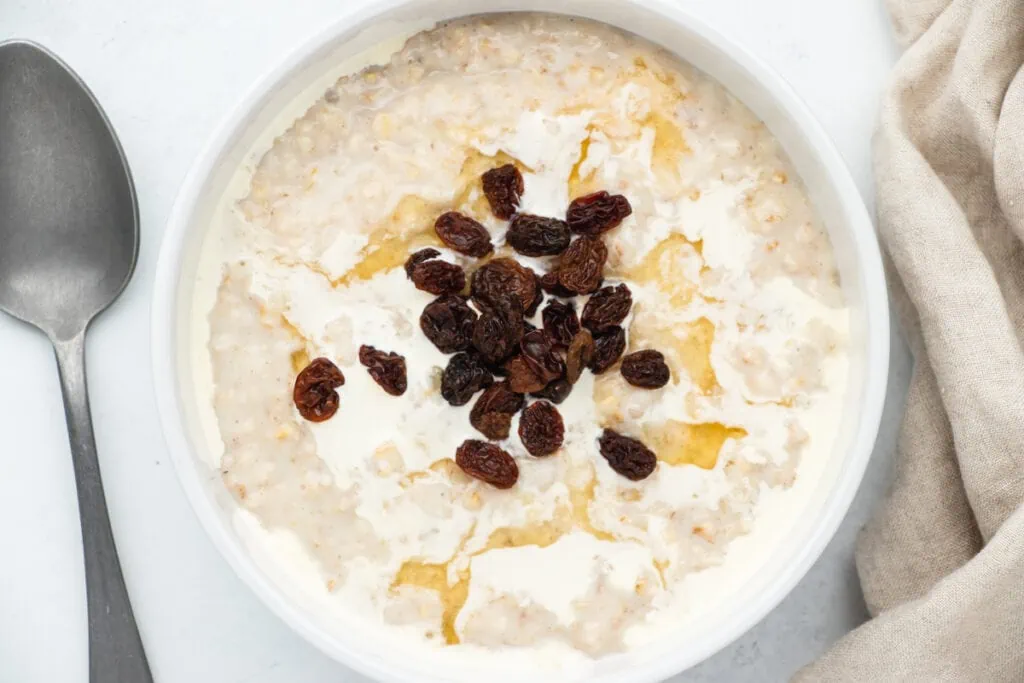 porridge topped with cream, raisins and golden syrup